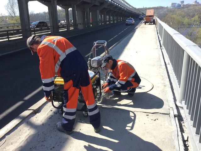В Киеве закрашивают в серый патриотические желто-синие перила моста Метро