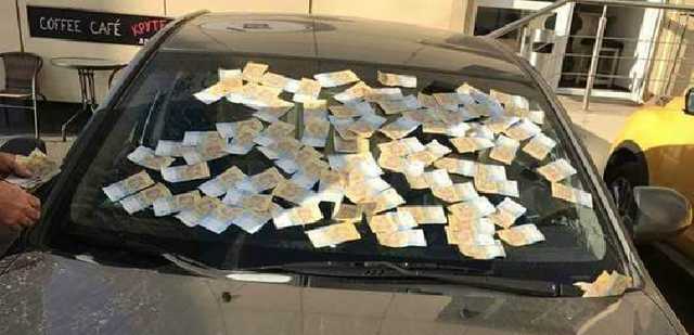 В Киеве лобовое стекло авто полностью заклеили деньгами