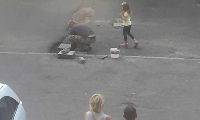 В Киеве мужчина подручными средствами самостоятельно залатал ямы на дороге