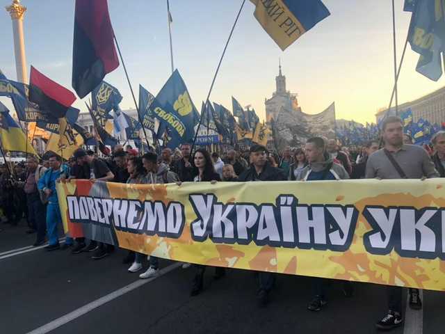 На марше УПА в Киеве участница Femen пронесла огромный баннер "Повернемо Україну українцям"