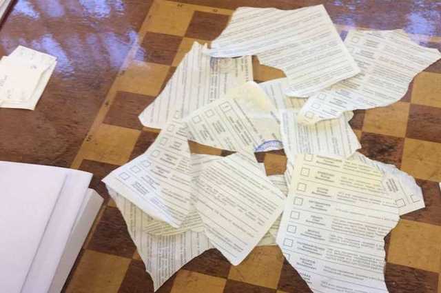 Появилось видео, как в Днепре мужчина порубил стопку бюллетеней топором