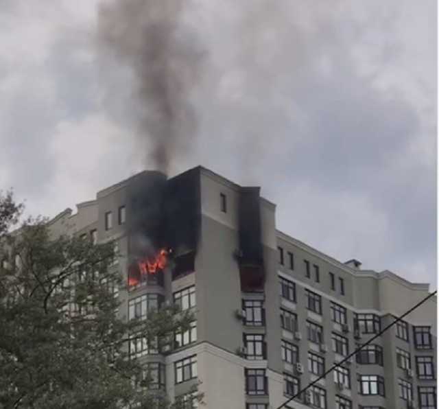 У Києві палає багатоповерхівка: жінка рятується від полум’я, стоячи на кондиціонері