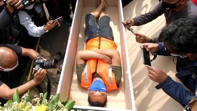 В Джакарте полиция людей без маски просит полежать в гробу