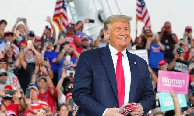 Трамп вышел на многолюдный митинг с открытым лицом и бросал маски в толпу