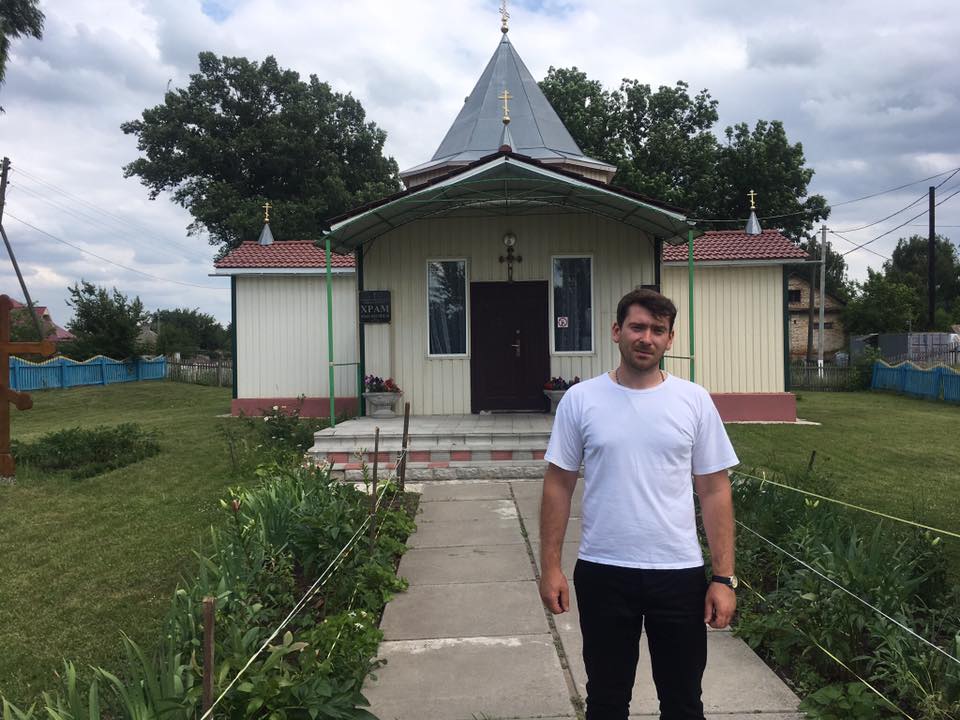 Отець Всеволод на фоні церкви Іоана Хрестителя Отець Всеволод на фоні церкви Іоана Хрестителя