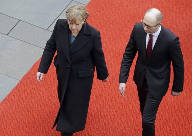 German Chancellor Angela Merkel, left, and the Prime Minister of Ukraine Arseniy Yatsenyuk, right, walk on the red carpet during a military welcome ceremony at the chancellery in Berlin, Germany, Thursday, Jan. 8, 2015. (AP Photo/Michael Sohn) dqxikeidqxiqxxant