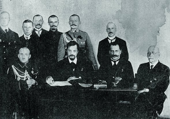 Члени делегації Української Держави на мирних переговорах із представниками Росії в Києві, червень, 1918 рік. Сидять (зліва направо): представник військового міністерства Олександр Сливинський, юрист і голова делегації Сергій Шелухін, міністр закордонних справ Дмитро Дорошенко, професор міжнародного права Отто Ейхельман. Головним питанням переговорників було впорядкування кордонів