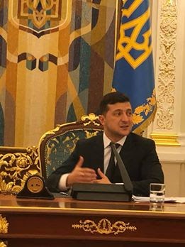 Image may contain: 1 person, standing and suit