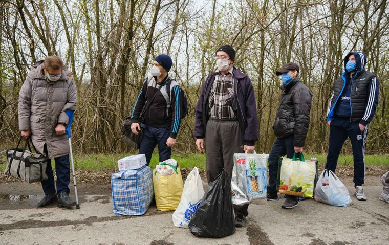 Обмененные пленные ждут со своими вещами во время обмена пленных между украинскими военными и пророссийскими боевиками, недалеко от пункта пропуска Майорское у оккупированного боевиками города Горловка, Донецкая область, Украина, 16 апреля 2020 года