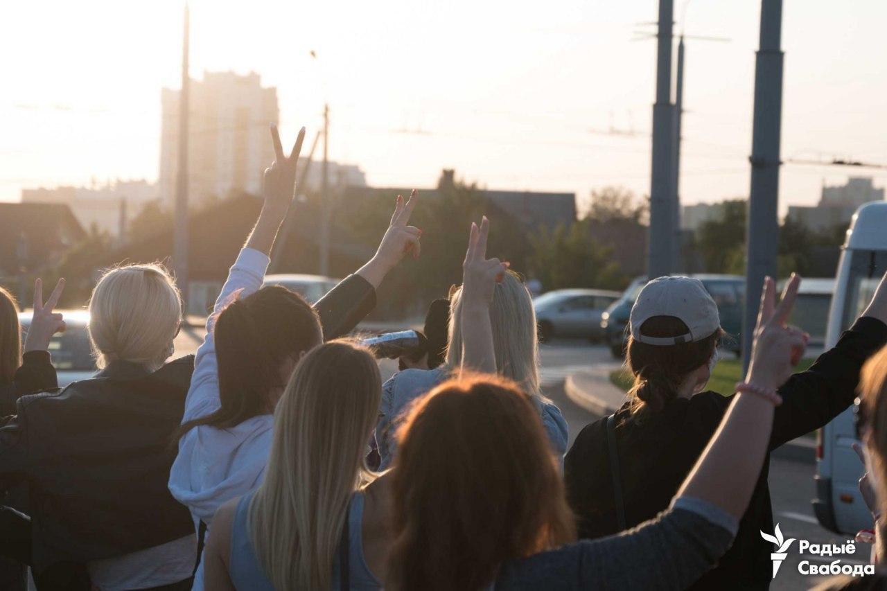 Люди хлопают в ладоши и показывают знак победы.