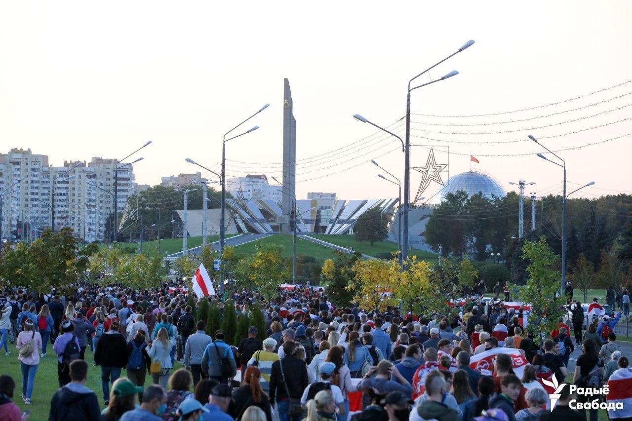 Протестующие идут к стелле.