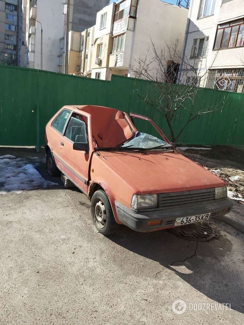 Рядом с домом до сих пор стоит расплющенный автомобиль.