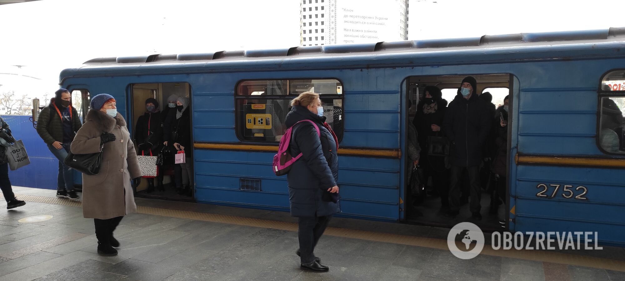 В вагонах метро люди стоят без соблюдения дистанции.