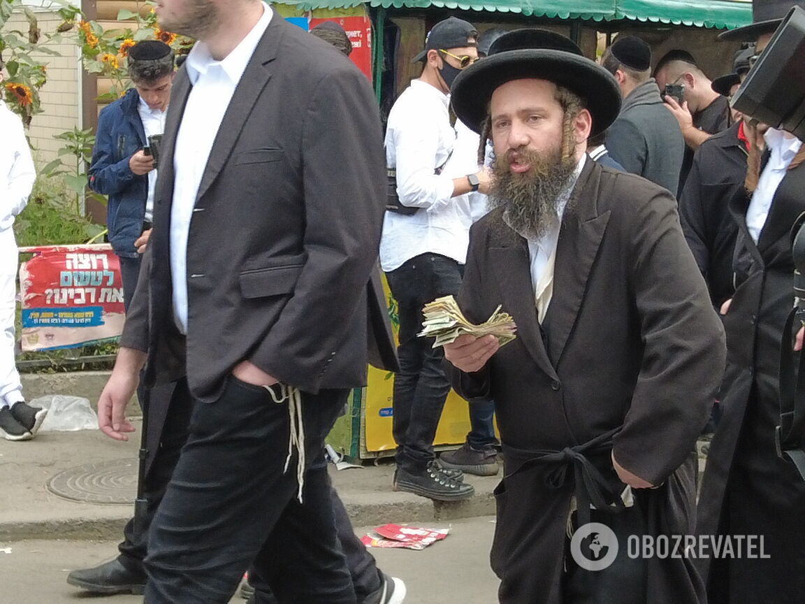 Паломник, которому другие хасиды вручали доллары после молитвы.