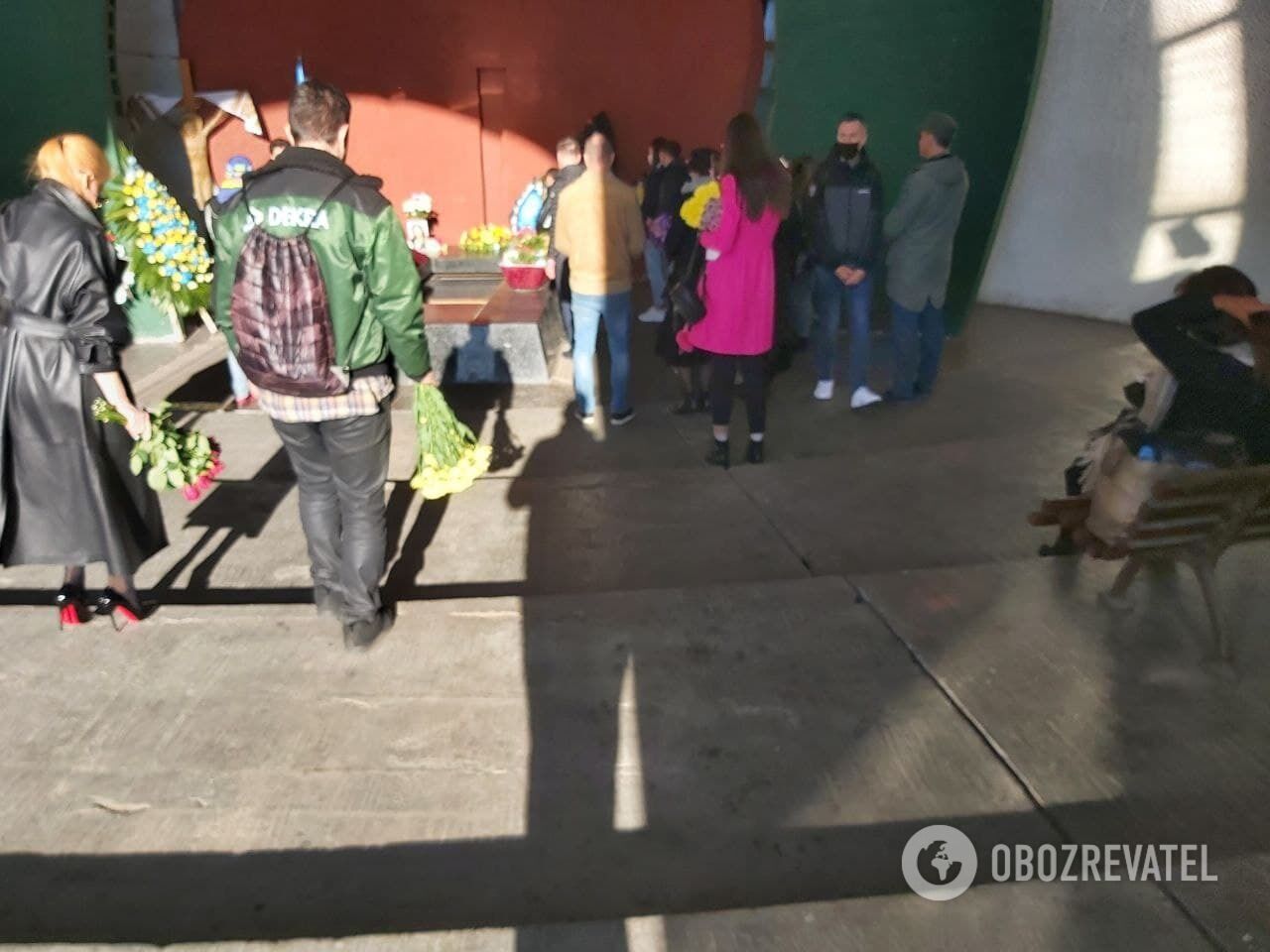 Люди несут цветы к праху Елены Волк