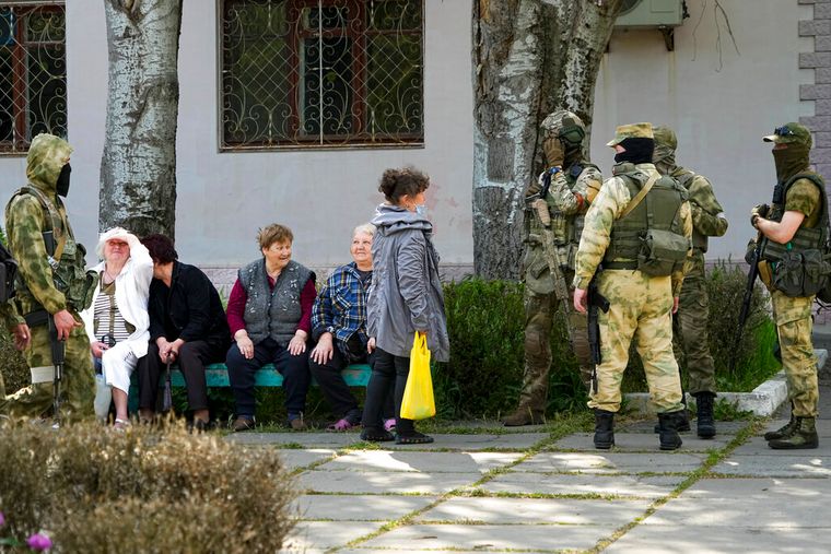 Пожилые женщины рядом с российскими солдатами в Херсоне, 20 мая 2022 года