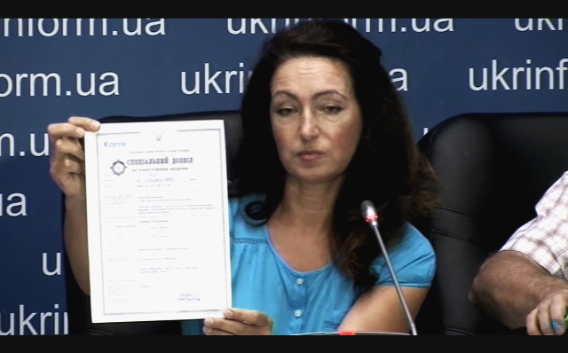 Арбітражна керуюча Олена Левкович демонструє спецдозвіл Укрбурштину на дослідно-промислову розробку 1027 га на прес-конференції 5 серпня у Києві. Кадр з відео агентства «Укрінформ»