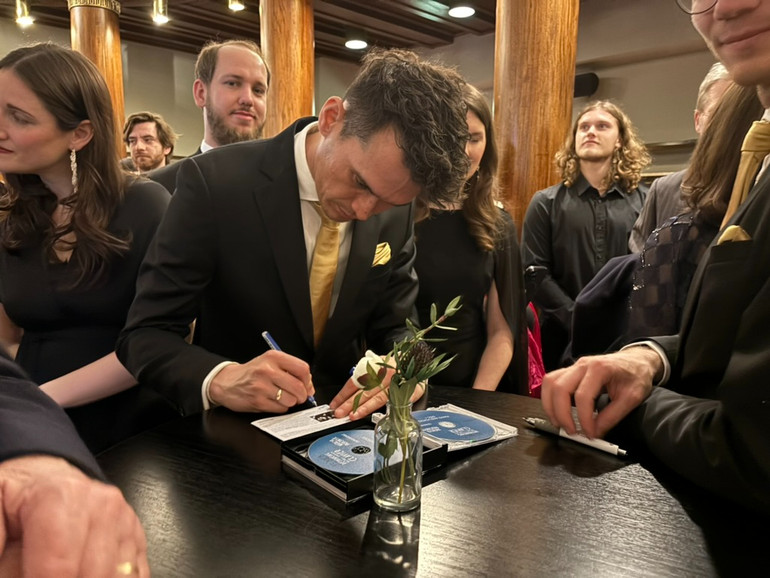 Один из послов подписывает открытку