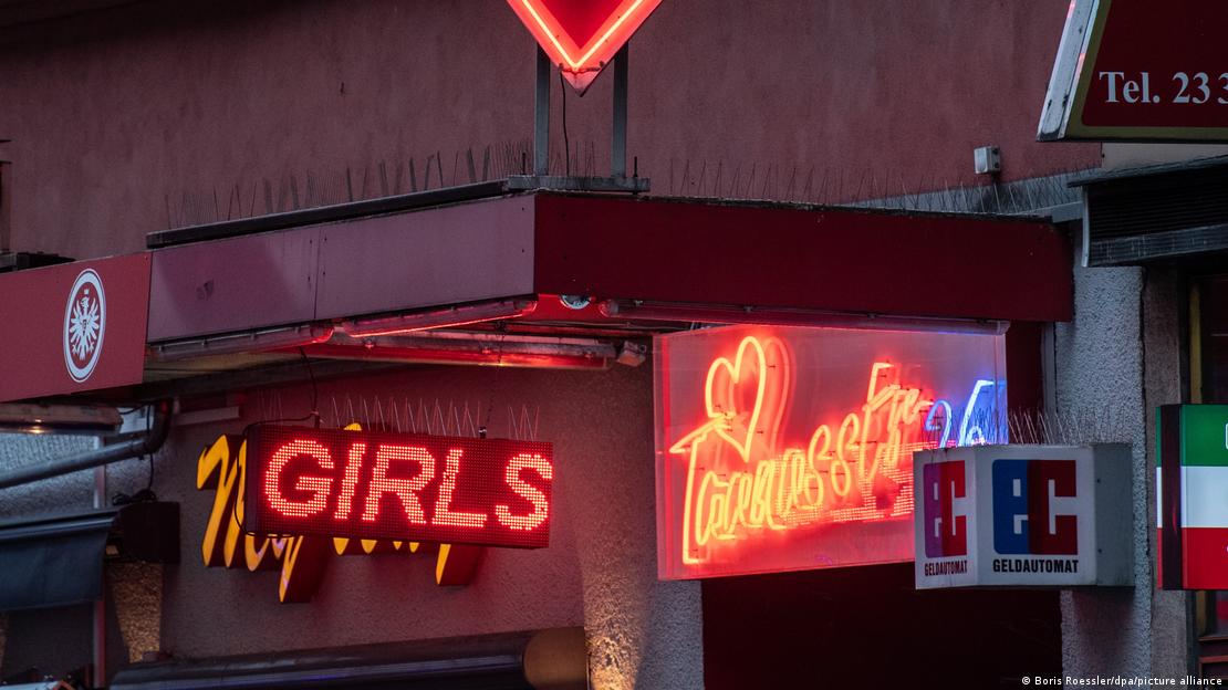 Неоновые вывески перед входом в олин из общественных домов недалеко от вокзала во Франкфурте-на-Майне