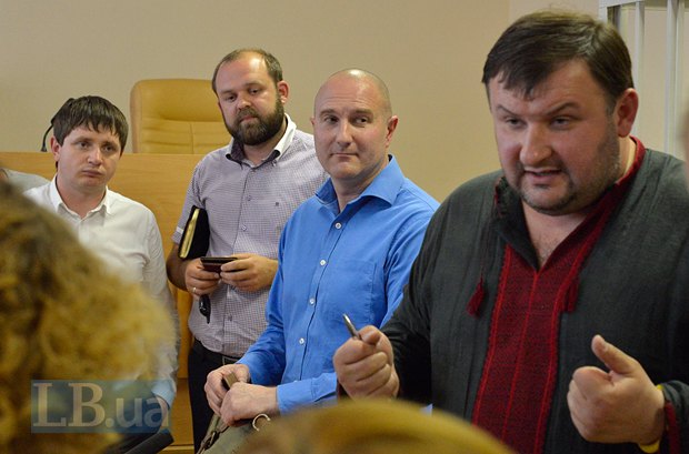 В синем - бывший командира роты Беркута Михаил Добровольский, подозреваемого в незаконном задержании активистов Автомайдана в январе 2014 года. Справа - адвокат Добровольского