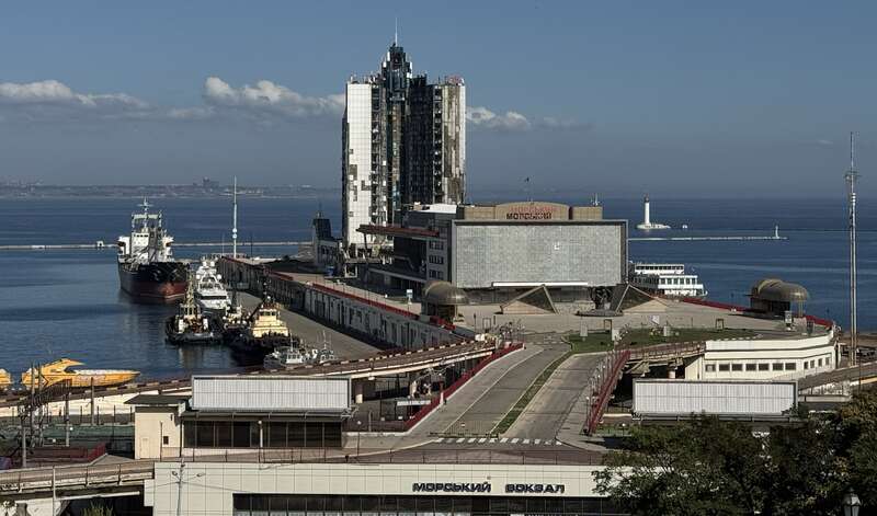 A large building next to a body of waterDescription automatically generated